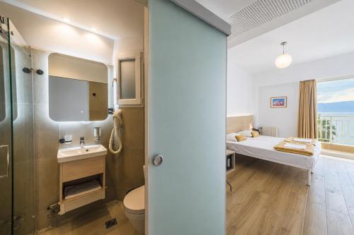 a bathroom with a bed and a sink and a toilet at HOTEL SISSY in Kamena Vourla