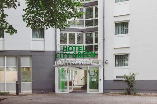 a hotel entrance with a sign over the door at Hotel City Green Hoppegarten in Hoppegarten