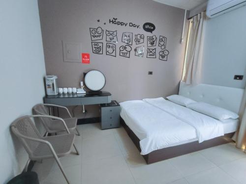 a bedroom with a bed and a desk and a mirror at Kinmen Huan Bei 88 B&B in Jincheng