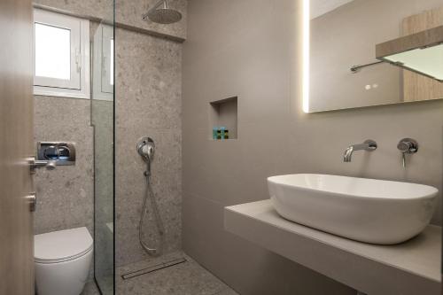 a bathroom with a sink and a toilet and a shower at Hotel Sarti Beach in Sarti