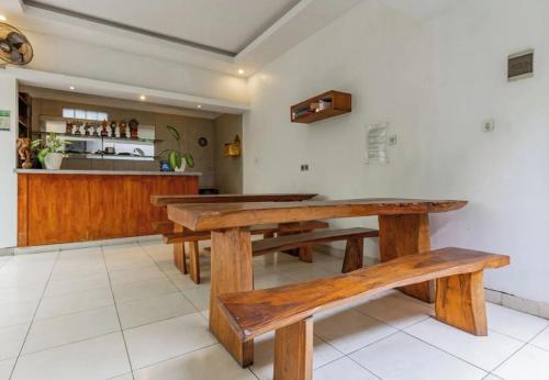 a dining room with wooden tables and a counter at Saren Guesthouse Bali in Kerobokan
