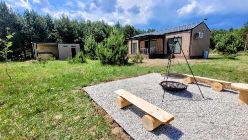 a playground with a swing and a house at Wiosłem w Hamaku Domek nad Wkrą in Rybitwy