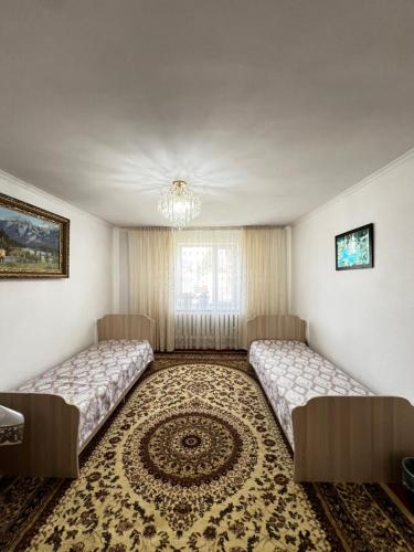 two beds in a room with a rug at Sultan in Kochkorka