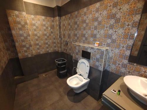 a bathroom with a toilet and a sink at Hotel The Palassio in Kānpur