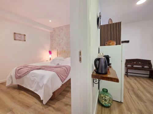 a bedroom with a bed and a table with a refrigerator at Cantinho da Muralha in Melgaço