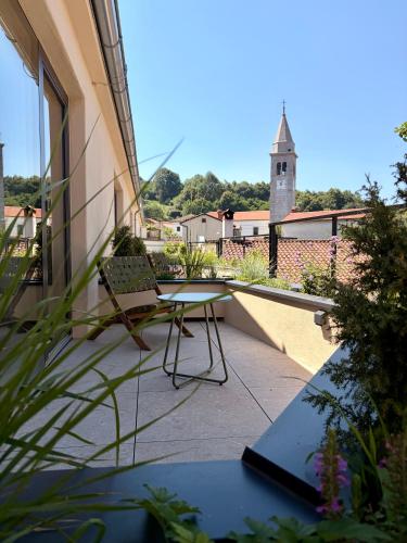 a patio with a table and a chair on a balcony at Josefina unique hotel, adult only in Kozina