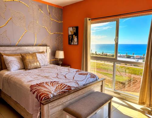 a bedroom with a bed and a view of the ocean at Rosarito Papas & ocean view Condo in Rosarito