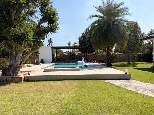 a house with a swimming pool in a yard at Arom Pool Villa Pattaya 1 in Na Jomtien