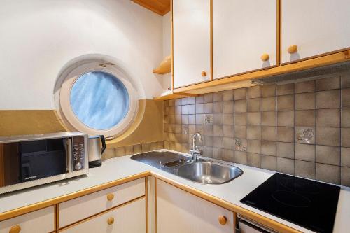 a kitchen with a sink and a window at Apartments Mupan St. Vigil in San Vigilio Di Marebbe