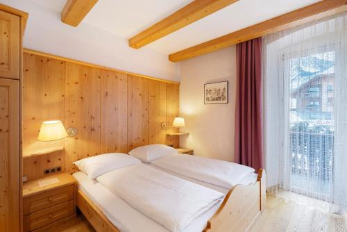 a bedroom with a bed and a large window at Apartments Mupan St. Vigil in San Vigilio Di Marebbe