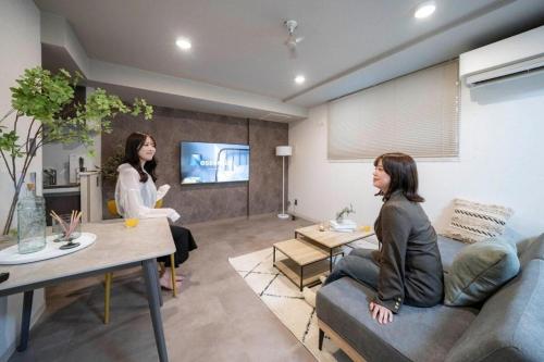 two women are sitting in a living room at Lotus south in Sapporo