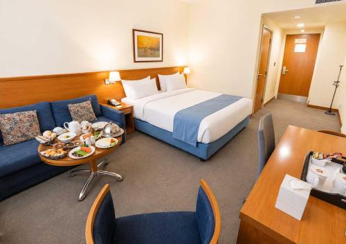a hotel room with a bed and a couch at Lancaster Tamar Hotel- Hadath in Beirut