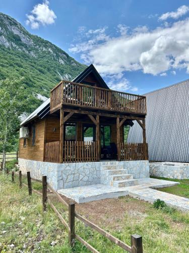 a log cabin with a deck on a hill at Komarnica Forest Owl 3 in Šavnik