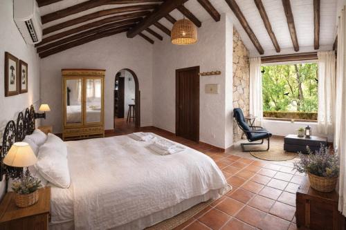 a bedroom with a large white bed and a window at Casa Rural Crisol Spa in Arenas de San Pedro