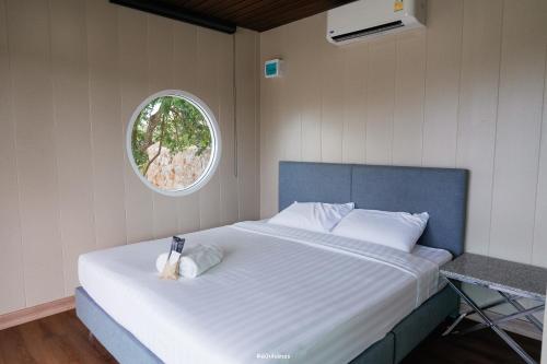 a bedroom with a large white bed with a window at Arom Pool Villa Pattaya 1 in Na Jomtien