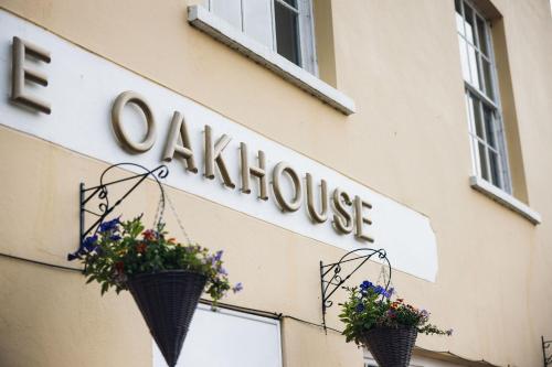two baskets on the side of a building with flowers in them at Oak House Hotel in Axbridge