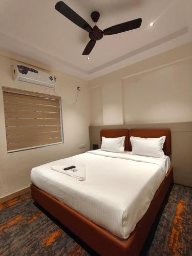 a bedroom with a large bed with a ceiling fan at SW Hotel MG Road in Bangalore