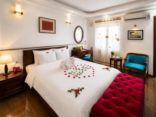 a bedroom with a large white bed with roses on it at Hanoi Luxury Hotel - Old Quarter in Hanoi