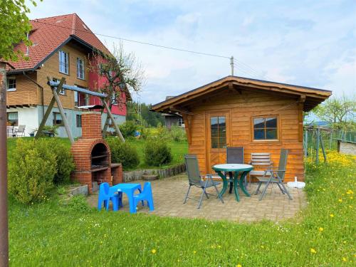 a small cabin with a table and chairs in the yard at Süßen Häusle in Breitnau
