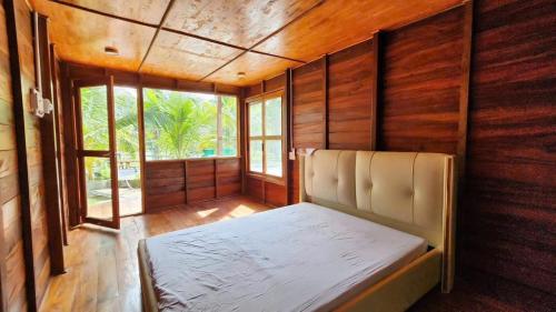 a bedroom with a bed in a room with wooden walls at Đức Hòa homestay in Ấp Thố Mố (1)