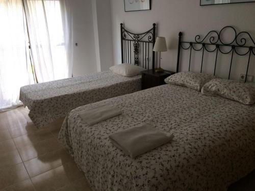 two beds in a bedroom with two pillows on them at Apartamento Mateos 50 por ciento dcto directo in Murcia