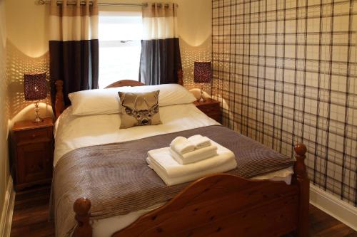 a bedroom with a bed with two towels on it at The Windmill Inn - Whitby in Whitby