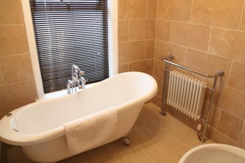 a bath tub in a bathroom with a window at The Windmill Inn - Whitby in Whitby