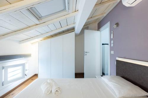 a bedroom with a white bed with two towels on it at Asinelli, Bologna by Short Holidays in Bologna