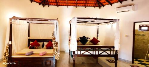 two beds in a room with red pillows at Freedom Life Yala in Tissamaharama