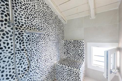 a bathroom with a black and white patterned wall at Asinelli, Bologna by Short Holidays in Bologna