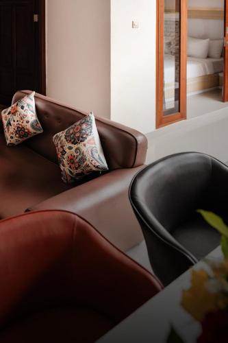 a living room with a couch and two chairs at oemah samiya in Keramas