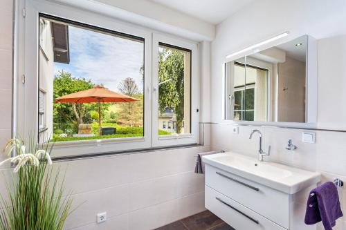 a bathroom with a sink and a window with an umbrella at Ferienwohnung Kleine Auszeit in Eslohe