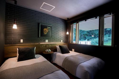 a room with two beds and a window at STARRY Residence Suite Hakuba Happo-one in Hakuba