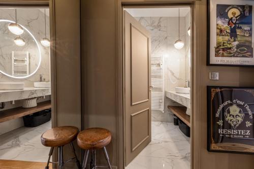 a bathroom with two stools in front of a door at Le Duval 66 in Pontarlier