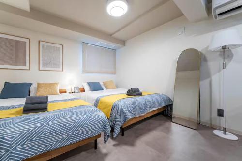 a bedroom with two beds and a tv at Lotus south in Sapporo