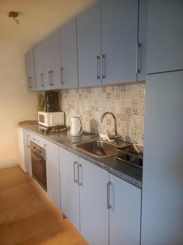 a kitchen with white cabinets and a sink at Stara Stajnia Moszyce - Apartament w Dolinie Baryczy in Twardogóra