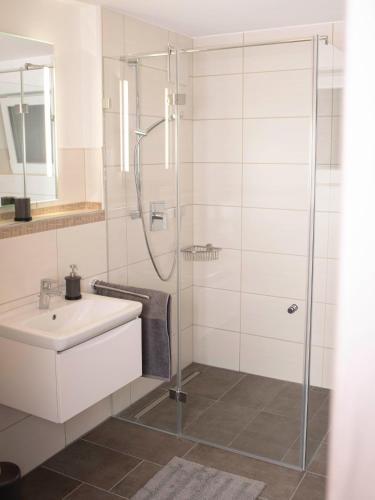 a white bathroom with a shower and a sink at Bantlehof in Niedereschach