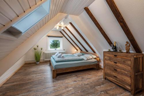 a attic bedroom with a bed and a skylight at Schwarzwald Chalet - Karlshütte in Neuweg