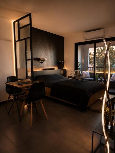 a bedroom with a bed and a table and a window at Jacuzzi, massage et plage ! in Fréjus