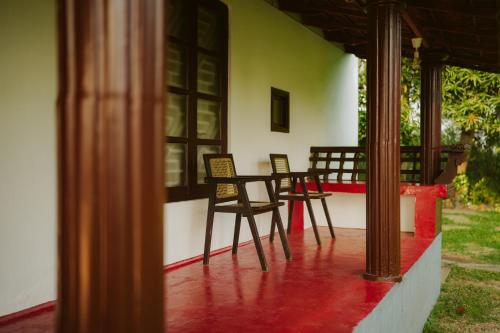 two chairs sitting on the porch of a house at Alleppey Backwater Resort in Alleppey