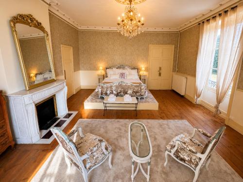 a bedroom with a bed and chairs and a fireplace at Queen's Escape in Martel