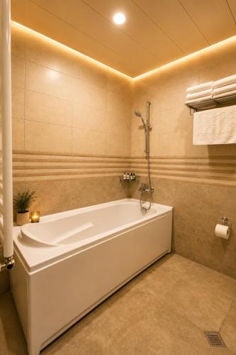 a white bath tub in a bathroom at Hotel Imperial House in Tbilisi City