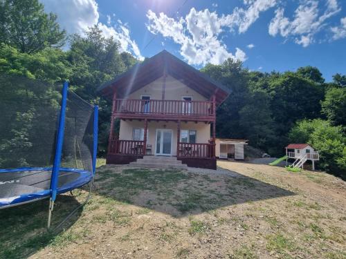 a small house with a porch and a swing at Liziera Cabin Malaia in Malaia