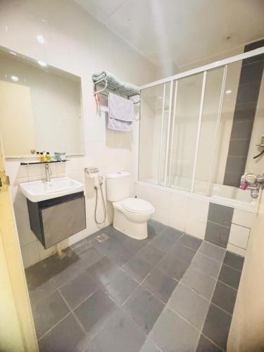 a white bathroom with a toilet and a sink at Silver Place Marina Island Lumut in Lumut