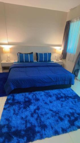 a bedroom with a blue bed with a blue rug at Silver Place Marina Island Lumut in Lumut