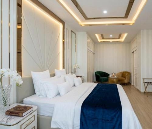 a bedroom with a large white bed with white pillows at Tak Residence Hotel in Tak