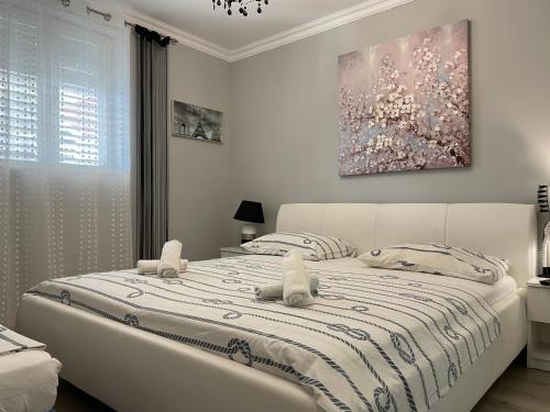 a bedroom with a large white bed with two pillows at Apartmani Anđelo, Tommy, Leon in Bibinje