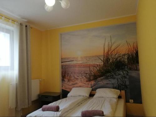 two beds in a room with a painting on the wall at Apartament Orłowo in Gdynia