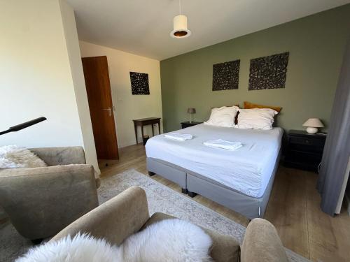 a bedroom with a bed and a couch and chairs at Apartment Osso 3 in Arnhem