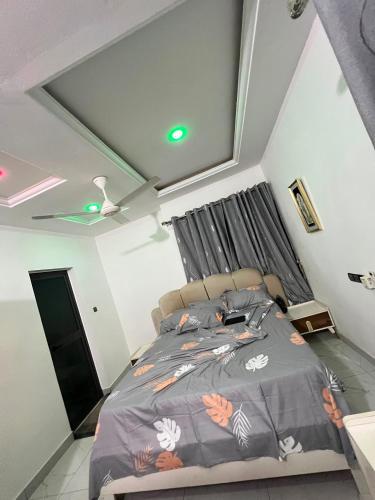 a bedroom with a bed with a gray comforter at TGS home in Lomé